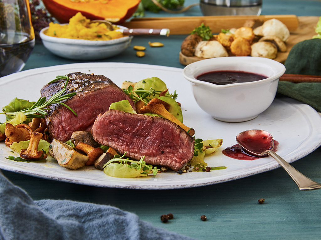 Rinderhüftsteak auf Kürbisstampf mit Pilzen, Rosenkohl­blättern und Cranberry-Jus